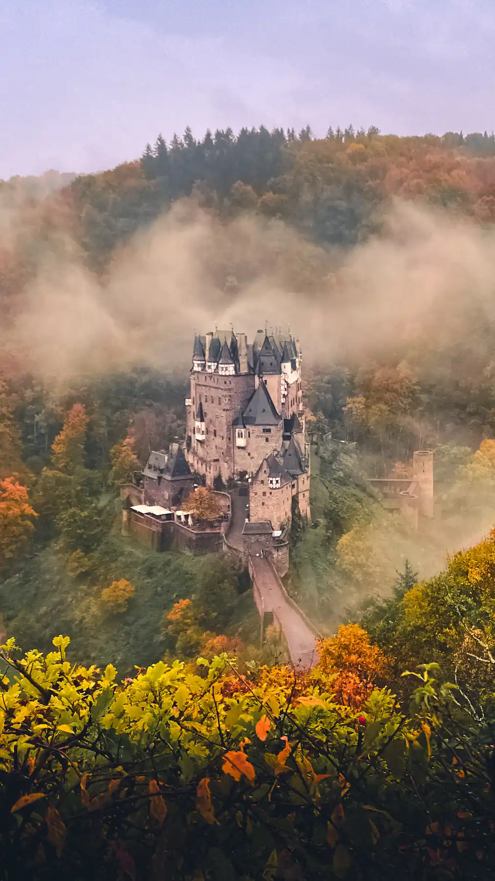 Burg Eltz surrounded by autumn forest and fog