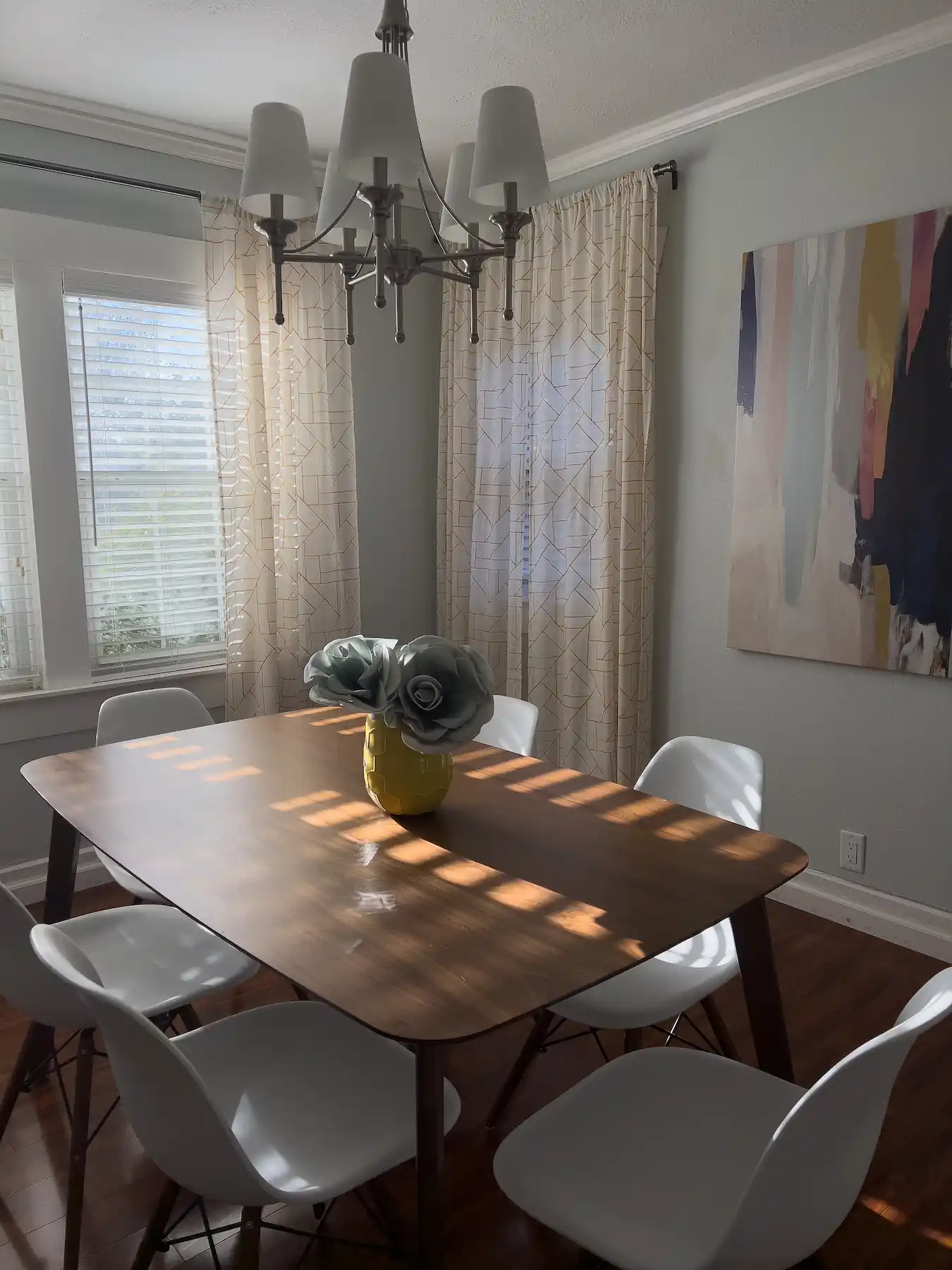 Dining table with chairs, ceiling lamp and painting